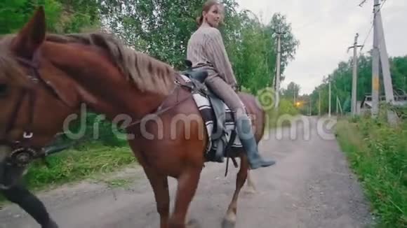 快乐的年轻女子骑在马背上视频的预览图