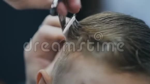 理发师正在理发店剪男孩头发专业理发师在理发店理发男孩视频的预览图