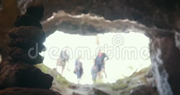 手工制作的石塔在洞穴前的朋友戴着头盔视频的预览图