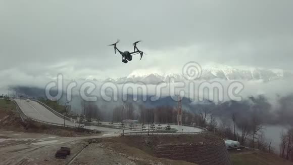 近距离的四架直升机无人机飞行在道路上山在白色的雾和雪的背景股票视频的预览图