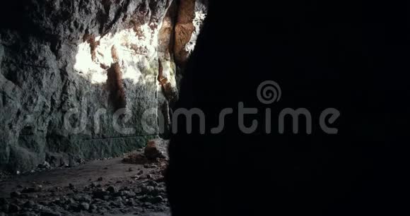 戴着头盔的年轻朋友用手电筒探索黑暗的洞穴视频的预览图