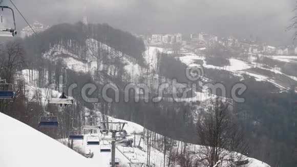 在山上在积雪覆盖的山丘和建筑物上特写索道吊舱库存录像滑雪视频的预览图