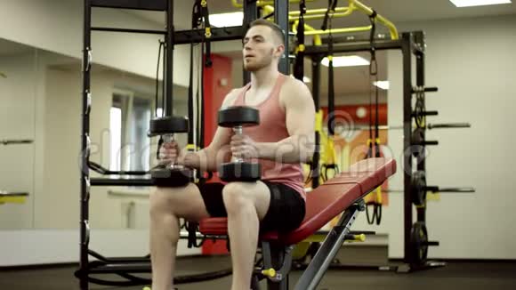 在健身房做哑铃式长凳按压练习的人视频的预览图