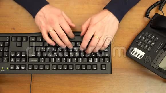手指在办公室手机附近的黑色键盘上打字视频的预览图