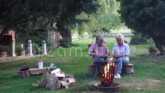 浪漫的篝火气氛和一对幸福的夫妇是在花园度过美好夜晚的最佳条件视频的预览图