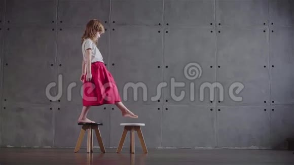 小女孩走在小椅子上视频的预览图