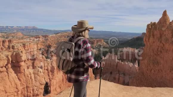 美国犹他州布莱斯峡谷一个徒步旅行的成熟女人沿着岩石边缘走视频的预览图