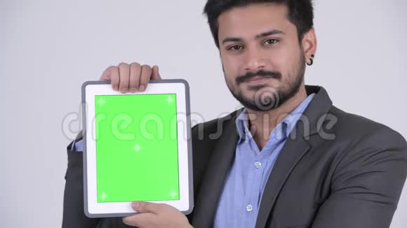 年轻快乐的印度商人展示数码平板电脑视频的预览图