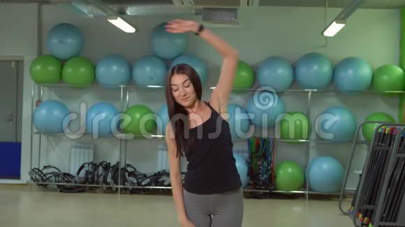 年轻女子在健身房训练前做热身运动健身理念视频的预览图