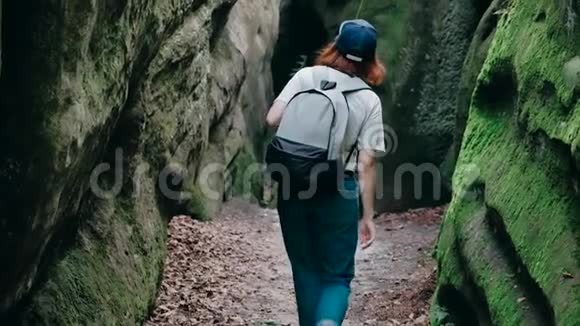 在山里徒步旅行一位年轻的曲棍球女子背着背包行走的后景视频的预览图