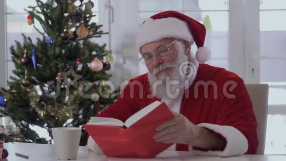 圣诞老人从杯子里喝东西读一本书视频的预览图