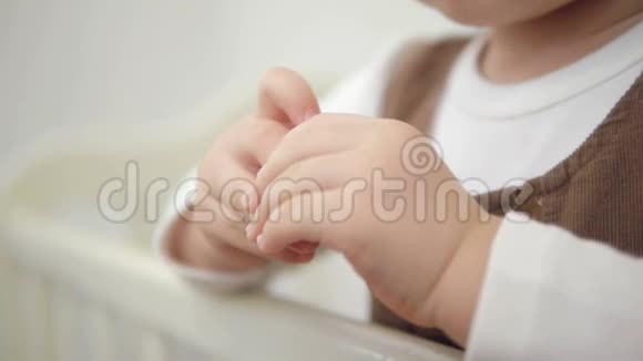 站在婴儿床上的小女孩的手的特写视频的预览图