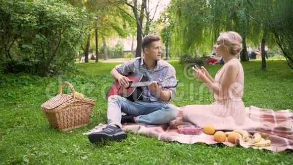 快乐的女孩和男朋友一起跳舞唱歌弹吉他约会视频的预览图
