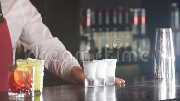 酒保把一些饮料从瓶子里倒入冷冻玻璃杯视频的预览图