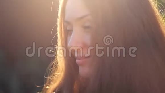 夕阳下一张年轻女子的美丽脸庞视频的预览图