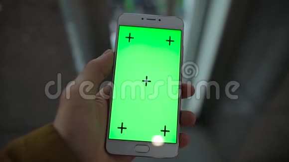 室内绿色屏幕的男性手持智能手机视频的预览图