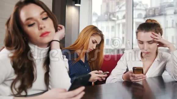 三个在胡克地方的年轻女人坐在他们的电话里视频的预览图