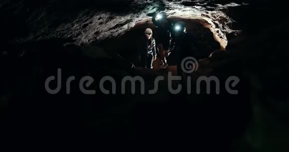 一群带手电筒的专家在黑暗的洞穴里行走视频的预览图