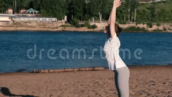 女人在城市河边的海滩上做瑜伽在巴东古斯塔萨纳的美丽景色视频的预览图