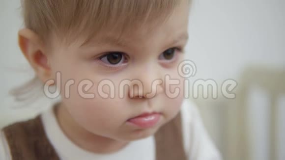 一个一岁半的小女孩站在婴儿床上严肃的特写视频的预览图