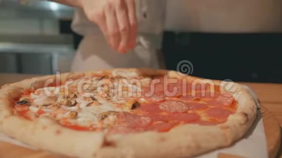 厨师用手撒点胡椒粉或香料比萨饼4K特写镜头视频的预览图