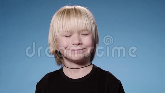 可爱的小男孩惊讶于纸屑和饼干蓝色背景超级慢动作视频的预览图