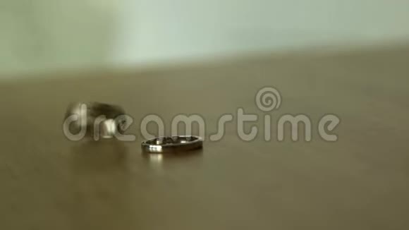 结婚金戒指订婚戒指在木制的库存餐桌上的结婚戒指视频的预览图