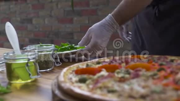 食品设计理念披萨制造商在意大利披萨店用新鲜草药装饰披萨过程准备视频的预览图