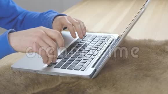 手在笔记本电脑键盘上打字站在木桌上的地毯上视频的预览图