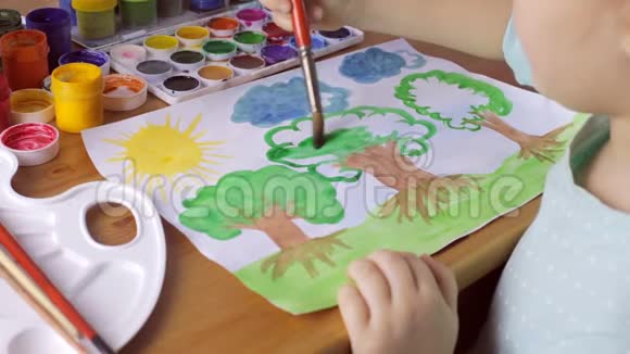 可爱的少女在白纸上画着绿叶子的棕树视频的预览图