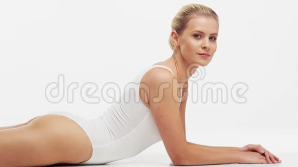 年轻美丽健康和自然的女人穿白色泳衣应用保湿霜按摩护肤脂肪视频的预览图