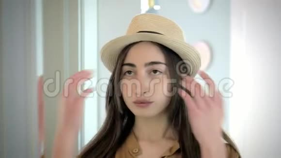 可爱的年轻白种人女孩戴着帽子照镜子视频的预览图