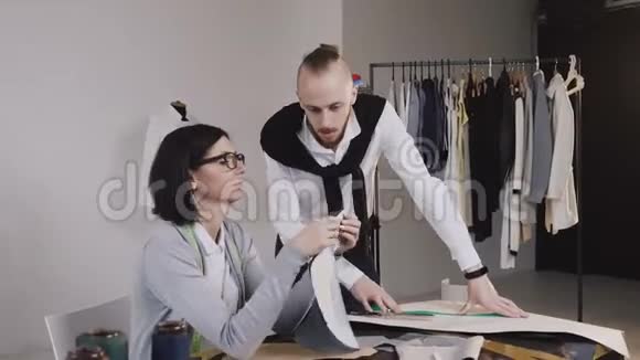两位裁缝白种人的时装设计师在美丽的办公室里坐着不同的布料图案视频的预览图