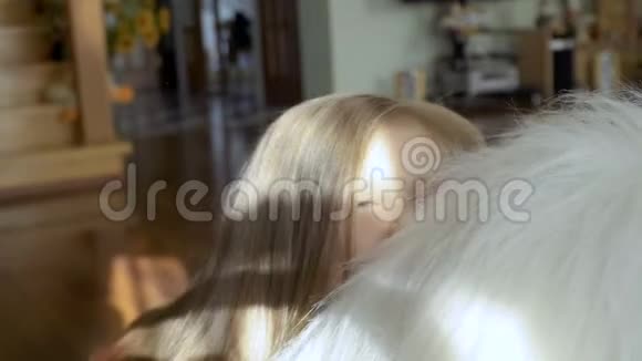 可爱的小女孩坐在柔软的大玩具上抚摸着她的头发挑逗着相机视频的预览图