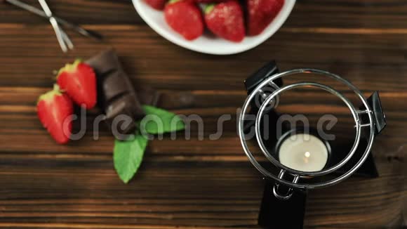 厨师把火锅放在桌子上木制背景的巧克力草莓软糖视频的预览图