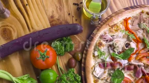 木制桌子背景上的热披萨和新鲜蔬菜食物背景意大利传统美食意大利顶级景观视频的预览图