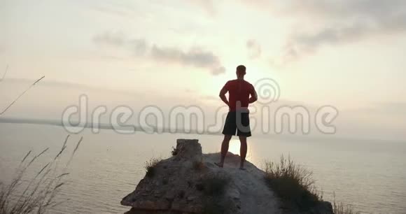 年轻人在海边的大石头上热身视频的预览图