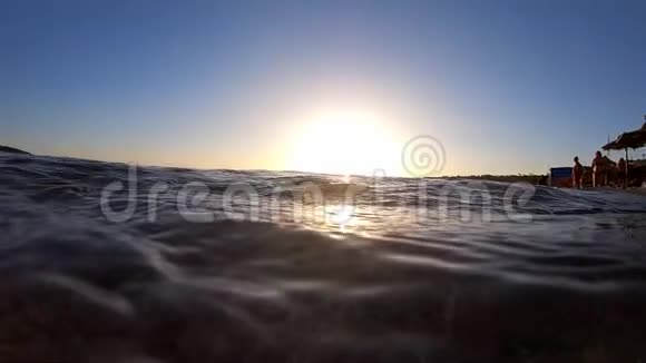 日落时靠近公共海岸的海面活动缓慢视频的预览图