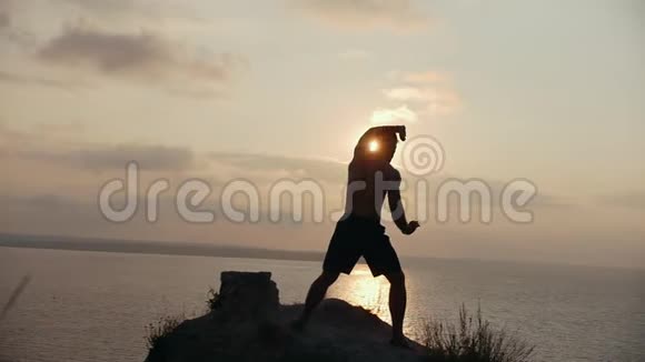 日出时年轻人在悬崖顶上热身视频的预览图