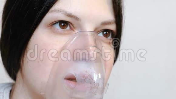 使用雾化器和吸入器进行治疗特写女人她的脸通过吸入面罩吸入前景视频的预览图