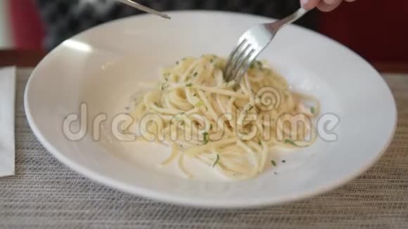 一个男人在叉子上用鲑鱼收集意大利面视频的预览图
