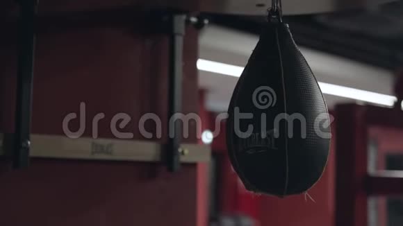 小型黑色皮革冲孔袋用于拳击手的训练悬挂在体育馆的天花板上库存录像气动视频的预览图