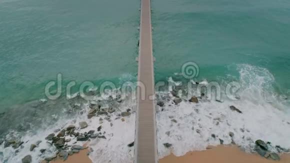 从无人驾驶飞机上俯瞰暴风雨海滩码头视频的预览图