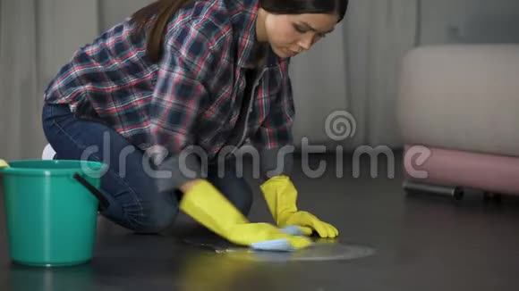 女士试图用特殊的去除剂去除地板上的污渍抛光视频的预览图