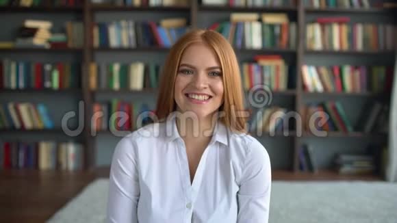 图书馆里美丽的年轻微笑的女学生的肖像女子微笑特写视频的预览图