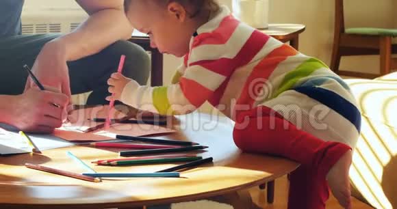 爸爸和他的小儿子在客厅用彩色铅笔画画视频的预览图