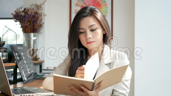 高清镜头美丽的商务女性在早上在城市的咖啡店里阅读和翻翻便条书页视频的预览图