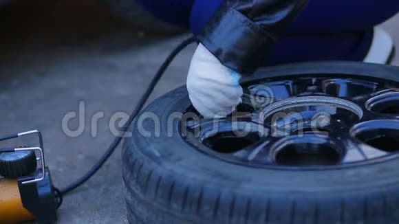 一个戴手套的女人正在用压缩机抽一个汽车轮胎视频的预览图