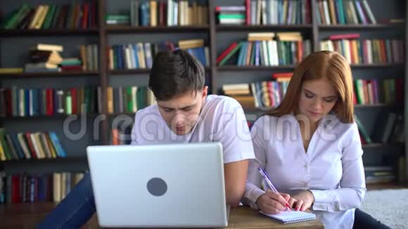 在笔记本电脑上学习的男女学生四千对学生一起学习两个学生在一起学习视频的预览图