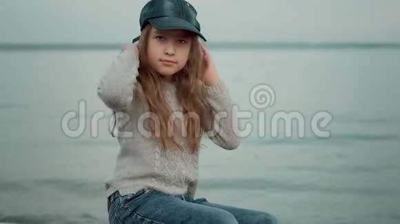孩子们沿着海滨散步一个穿暖和衣服的小女孩花时间在海滩上视频的预览图